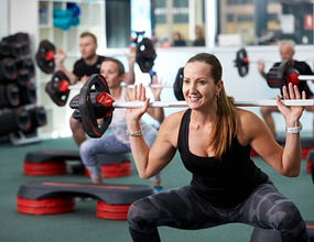Gym member using weights and enjoying group fitness class at Arena Joondalup