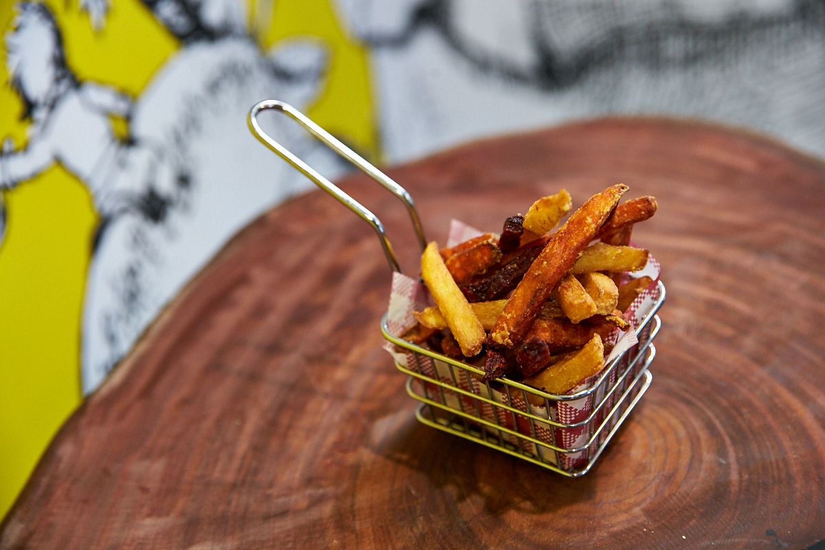 A photo of a basket of chips on a wood board