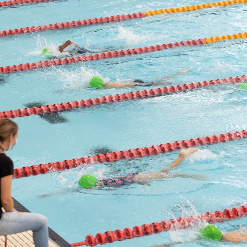 Swimmers coming in to the finish line of a swim school carnival race